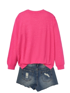 Detail view of pink long sleeve sweatshirt and distressed denim shorts back side