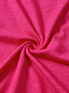 Detail shot of bright pink knitted fabric texture showing soft cotton weave material