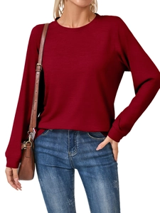 Detailed view of burgundy crewneck sweatshirt featuring ribbed cuffs and soft knit texture