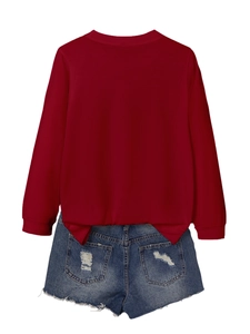 Flat lay of burgundy long sleeve crewneck top with distressed blue denim shorts