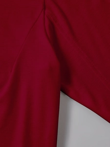 Macro detail of wine red long sleeve T-shirt showing reinforced seam stitching quality