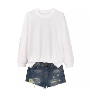 Women's casual white long-sleeved sweatshirt paired with distressed blue denim shorts