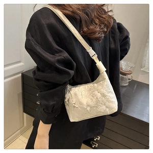 Détail du sac à bandoulière en dentelle florale blanche avec texture 3D et boucle réglable