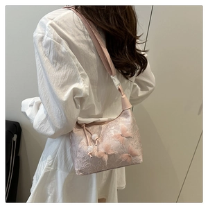 Détail du sac en dentelle rose avec papillons 3D et élégants accents de perles
