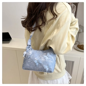 Détail du sac en dentelle lilas avec papillons 3D et bandoulière à cordon coulissant