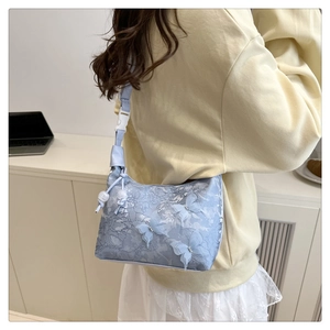 Détail du sac en dentelle bleu clair avec ornements papillons 3D et boucle en plastique