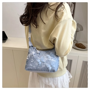 Détail du sac à bandoulière en dentelle bleu clair avec papillons 3D et strass