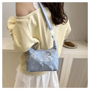 Détail du sac bandoulière bleu clair avec broderie florale et papillons 3D décoratifs