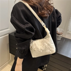 Sac baguette blanc en dentelle florale avec bandoulière réglable et détails cordons