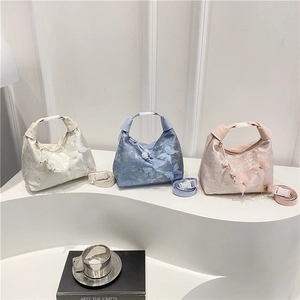 Trois sacs sous le bras à broderies nœuds en crème, bleu clair et rose sur des supports