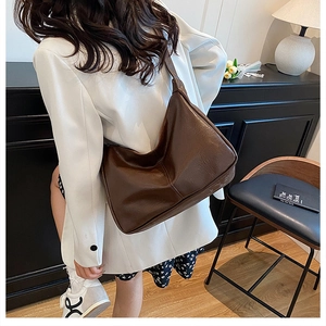 Detail of deep brown leather hobo bag showing its large capacity and soft pleated texture