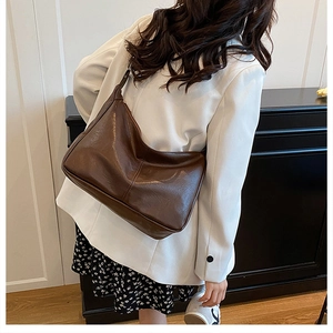 Gros plan d'un grand sac cabas vintage marron foncé en similicuir souple et doux