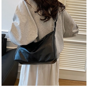 Hobo style black leather shoulder bag shown on model for realistic size and fit reference