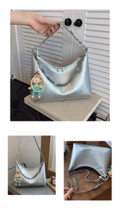 Detail of silver metallic tote bag with chain strap and cute pearl character charm