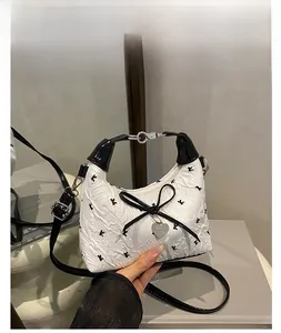 Detail of white PU leather bowling bag with black K print and bow heart pendant