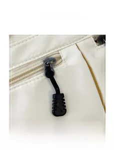 Detailed view of the smooth black zipper closure on an off-white canvas tote bag