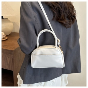 White minimalist pillow bag styled with a grey blazer for a modern elegant look