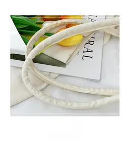 Close-up of padded cream faux leather handle on a minimalist tote bag with chic accents