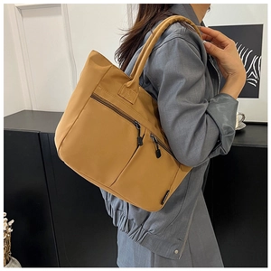 Nylon tote bag detail with three front zipper pockets and comfortable shoulder straps