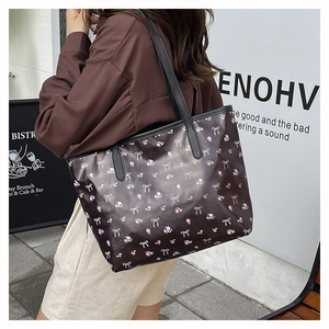 Detail of floral tote bag with bow prints and polished leather texture for women