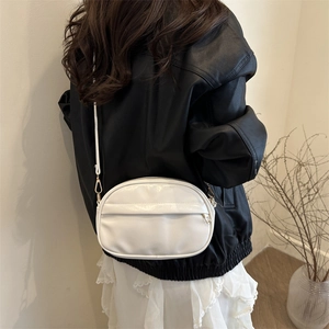 Minimalist white oval crossbody bag in PU leather shown on a model for size perspective