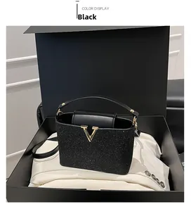 Detail of elegant black sequin handbag with gold V-logo in a luxury gift box