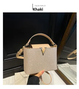 Detailed view of khaki mini bucket bag with sparkling rhinestones and golden V metal logo