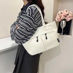 Minimalist white nylon tote bag with dual front zippers and black long handle straps