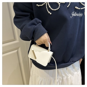 Gros plan d'un mini sac blanc à bandoulière avec décor doré et cuir synthétique fin