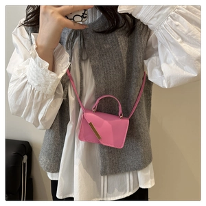 Vue détaillée d'un mini sac bandoulière rose avec garniture dorée et texture cuir