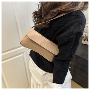 Chic beige glossy PU leather baguette bag worn by model with a black knit sweater