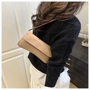 Model wearing a beige patent leather baguette bag for a minimalist stylish commuter look