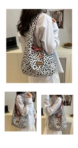 Detail of leopard print tote bag with brown fashion label and red checkered bow accent