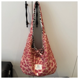 Detail of leopard print tote bag with pink patterns, bow decoration and inner lining