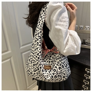 Detail of leopard print tote bag featuring a red floral lining and bow decoration