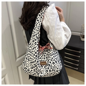 Detail of leopard print tote bag with leather Fashion tag and drawstring design