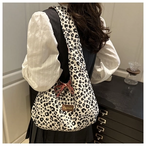 Detail of double-sided leopard print tote bag with brown fashion leather patch