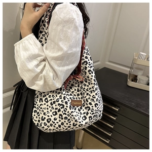 Detail of fashion leopard print tote bag featuring a brown leather label and canvas texture