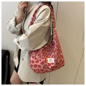 Detail of pink leopard print tote bag with shoulder strap and bow tie on a model