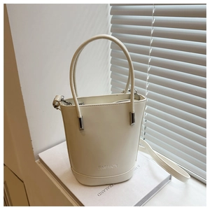 Detail of off-white bucket bag with embossed FASHION logo and silver hardware accents
