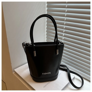 Detailed view of black bucket bag with silver FASHION lettering and crossbody strap