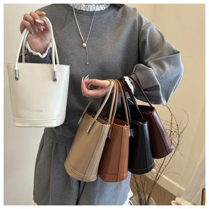 Close-up of five leather bucket bags in ivory, beige, caramel, black, and wine red
