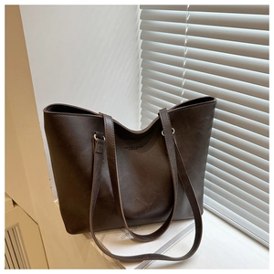 Detail of deep brown leather tote bag with vintage texture on white windowsill