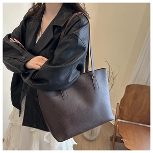 Detail of dark brown tote bag with marble texture and embossed fashion text for work