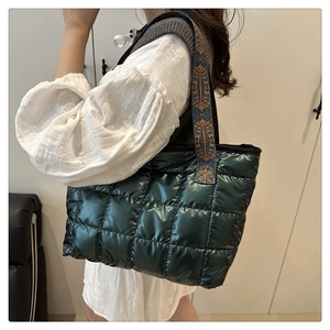 Détail du sac fourre-tout matelassé vert foncé avec une bandoulière jacquard ethnique