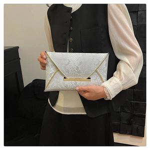 Close-up of white snakeskin texture envelope clutch with gold metal bar clasp detail