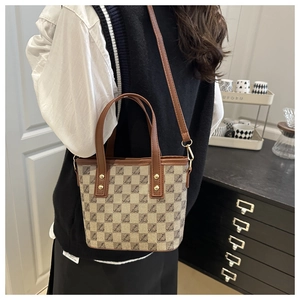 Detail of retro mini tote bag with monogram print and adjustable brown shoulder strap