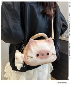 Détail du sac à bandoulière chat en peluche blanche porté avec veste en cuir et jupe