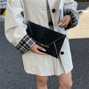Elegant black snakeskin envelope clutch bag with gold metal trim for women