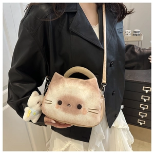 Gros plan détaillé du sac chat en peluche avec broderie et un joli petit pendentif